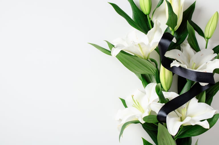 White lilies on white background symbolizing remembrance