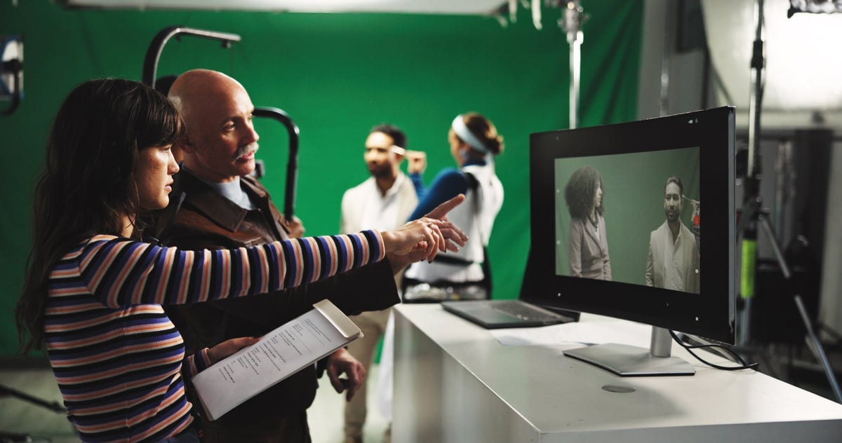 Directeur et producteur devant un écran vert avec l'équipe de production en studio