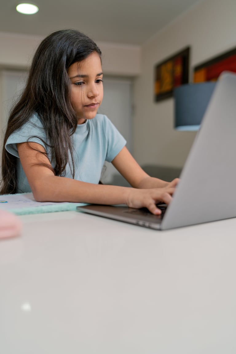Young girl receiving supportive guidance while learning on laptop at home