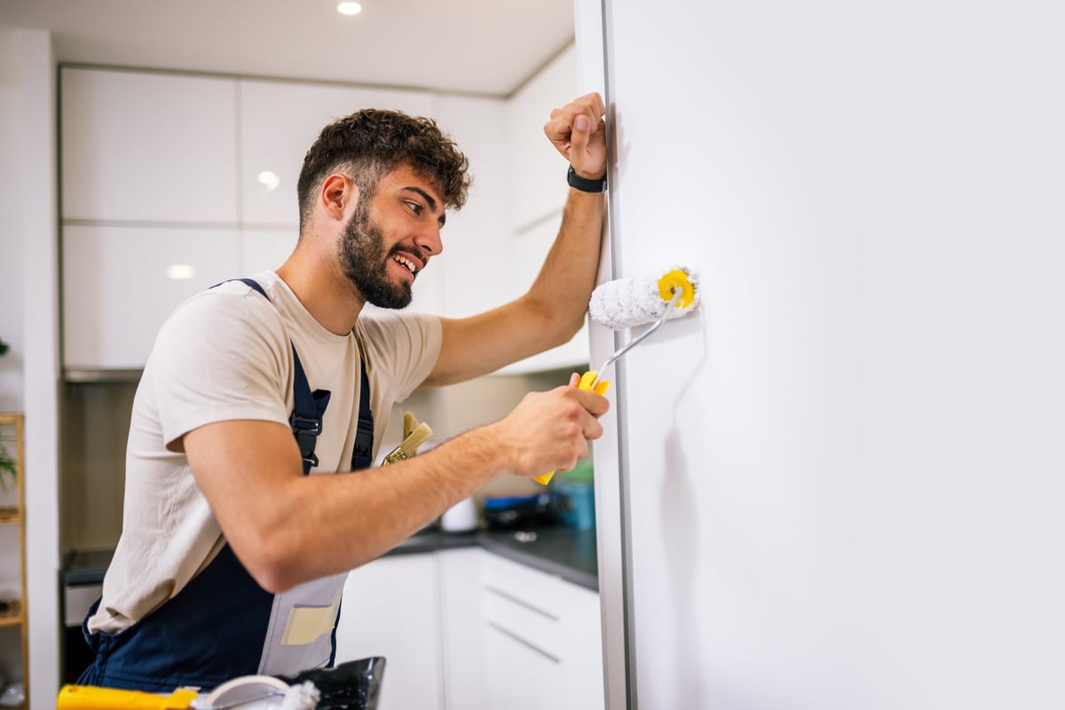 Imbianchino professionista al lavoro con pennello su parete
