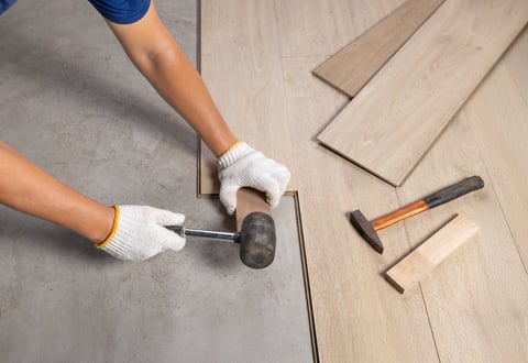 Worker installing interlocking laminate flooring