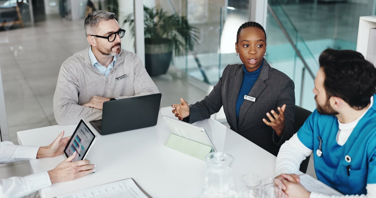 Diverse healthcare team reviewing data on a tablet during a collaborative meeting