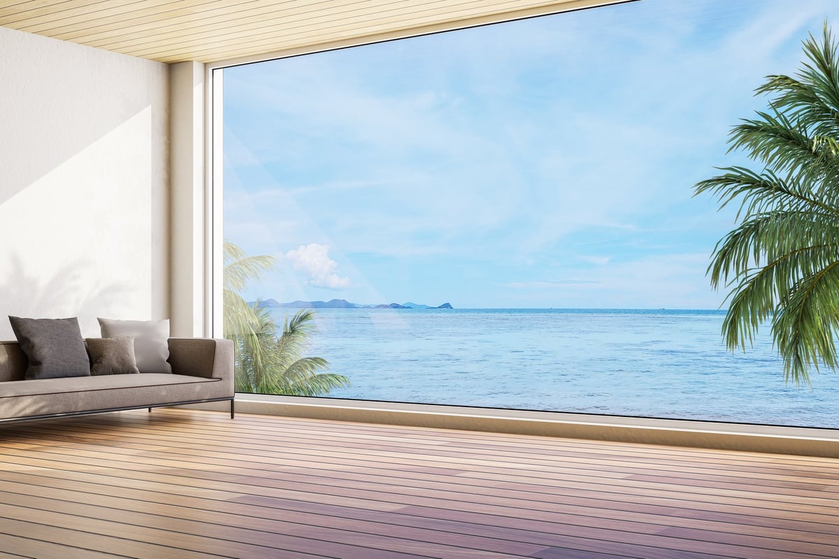 Modern contemporary style living room with sea view, wooden floors, white wall overlooking beautiful blue sea