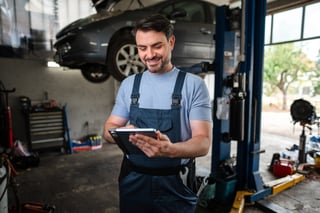 Mechanic using tablet in auto repair shop