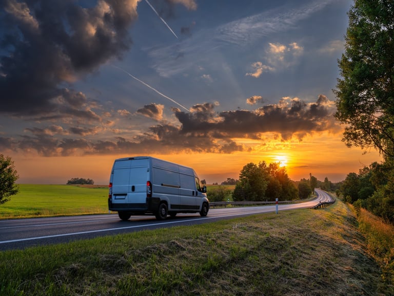 Delivery van driving at golden sunset
