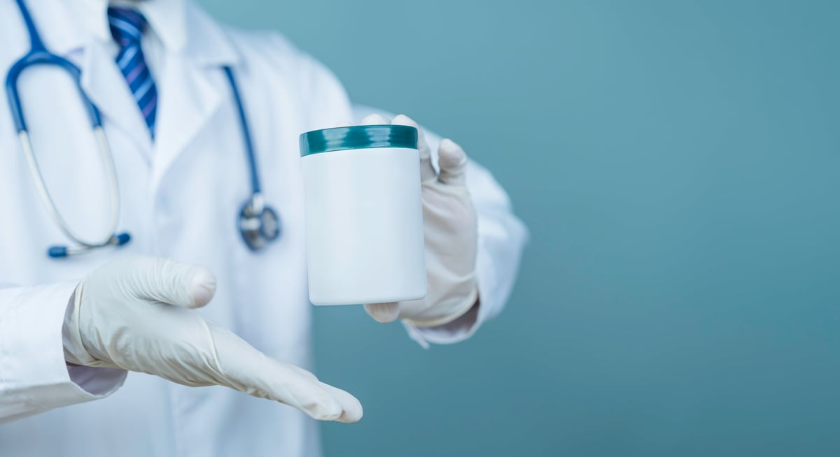 Doctor holding medicine container with gloves, testing sample for medical diagnosis