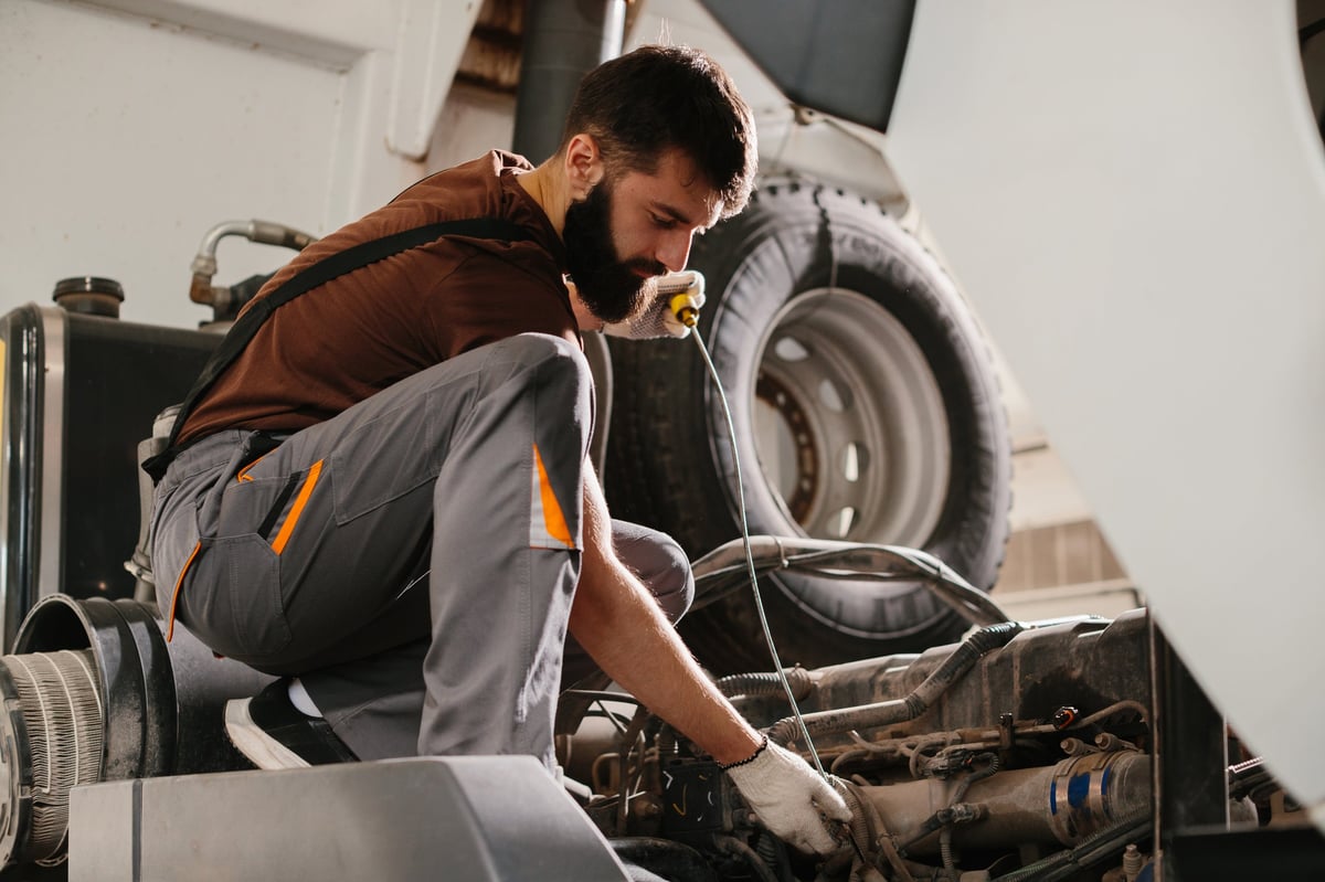 Skilled auto mechanic working on a truck engine