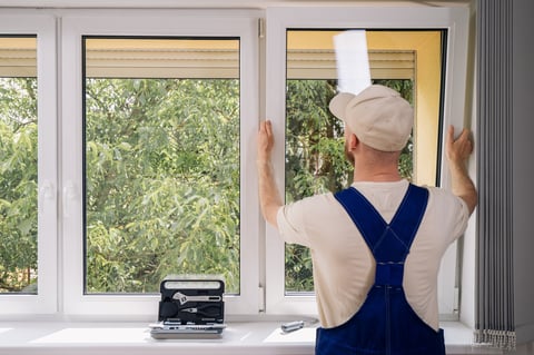 Professional installing new PVC window frame in residential building