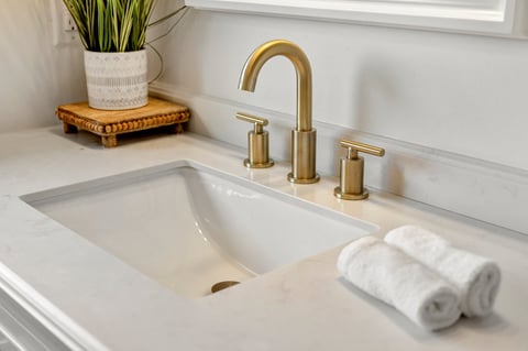 Sanitair renovatie — Moderne badkamer met gouden kraan