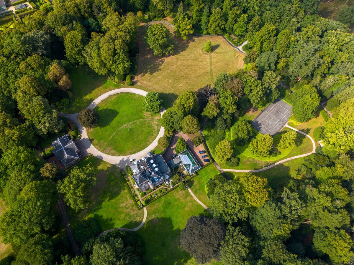 Aerial view of a forested country estate with surrounding fields