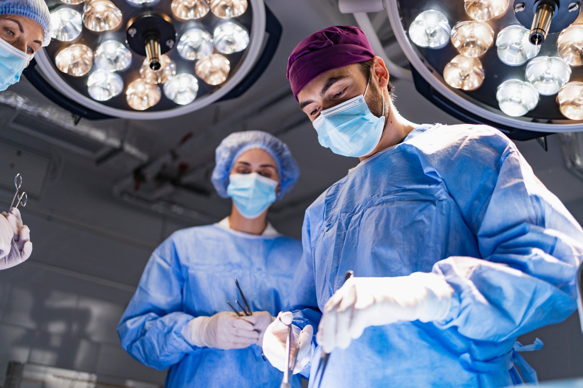 Equipo médico realizando un procedimiento en un quirófano moderno con iluminación quirúrgica