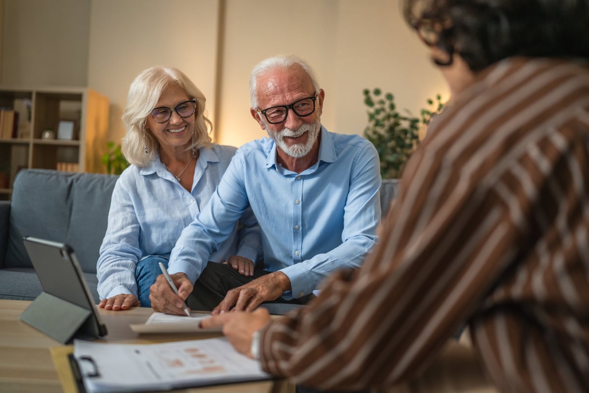 Couple signing documents with a financial adviser while recovering credit