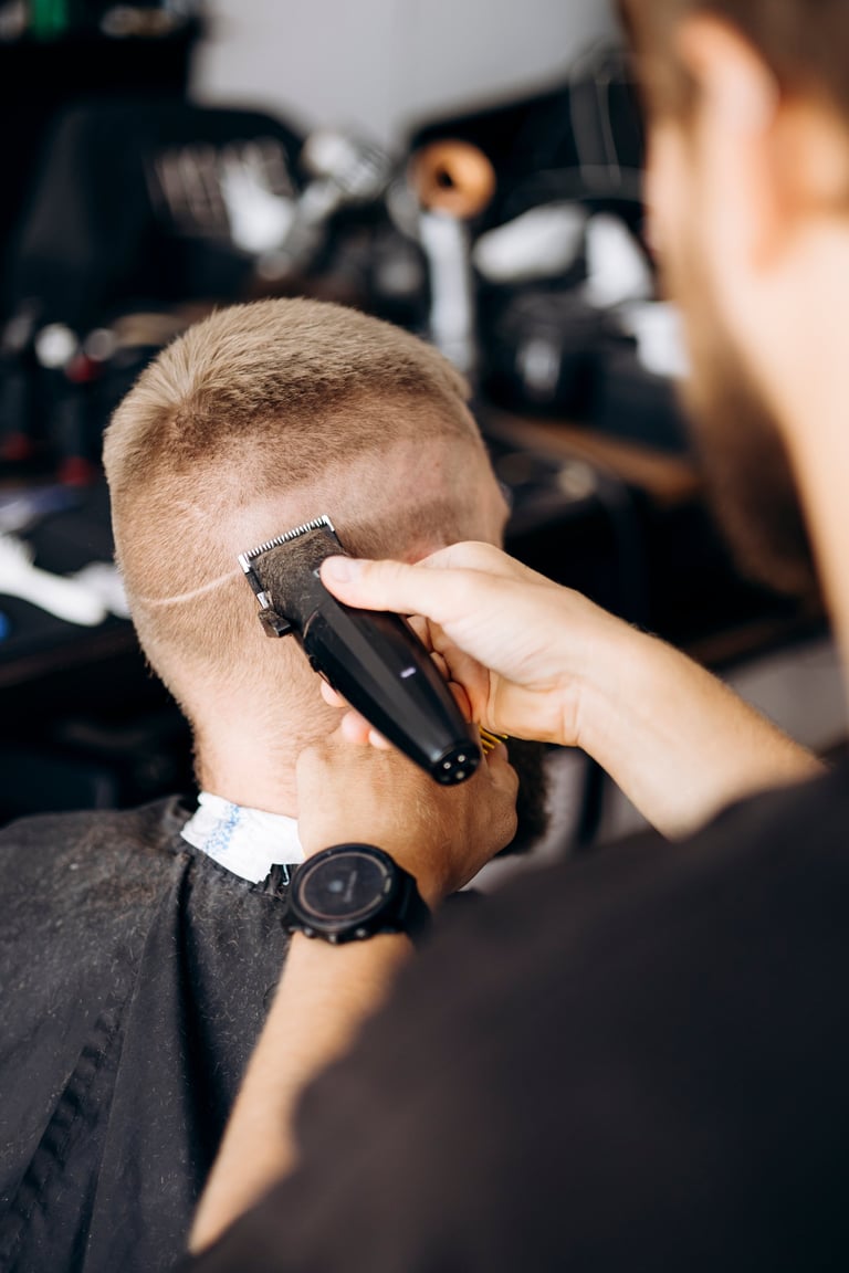 Professional barber trimming short male hair