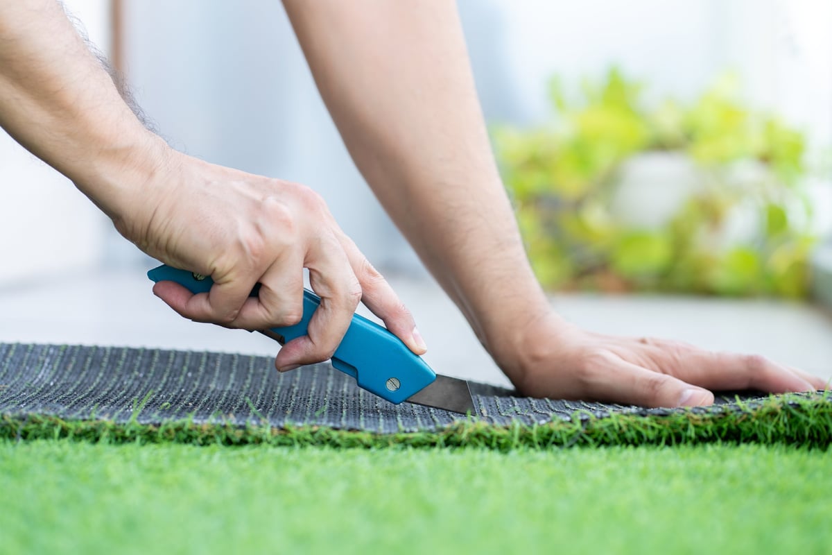 Landscaper carefully installing turf for a clean, even lawn in a Massachusetts garden