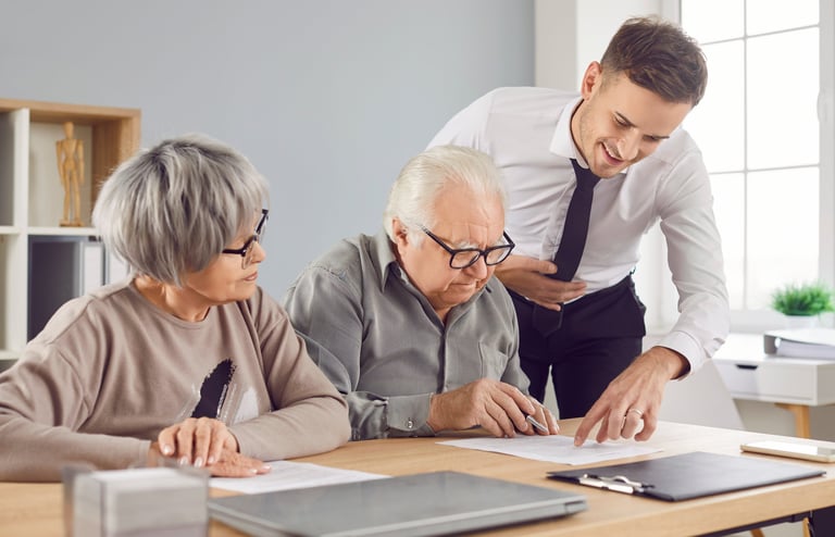 Elderly couple signing documents with advisor