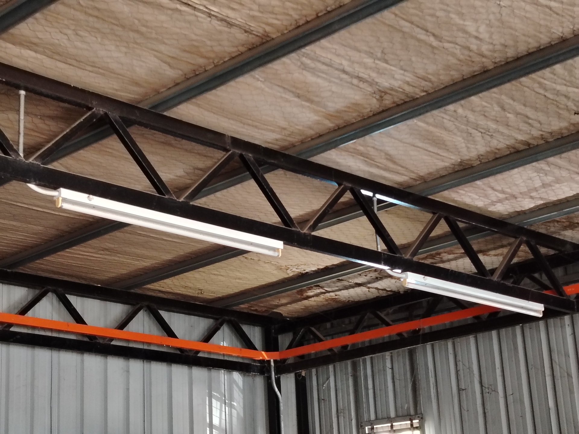 Builder insulating wooden frame house by spraying polyurethane foam