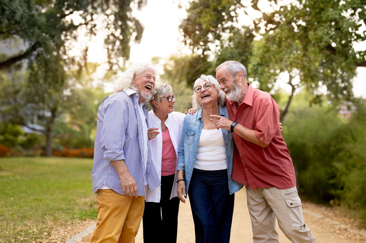Cuatro amigos mayores disfrutando una caminata en el parque