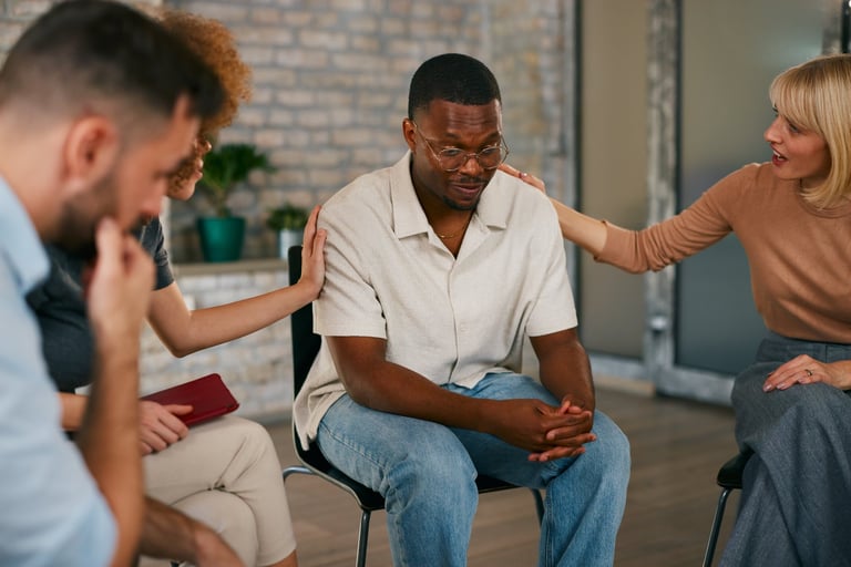 African American man receiving compassionate support during a community healing group session