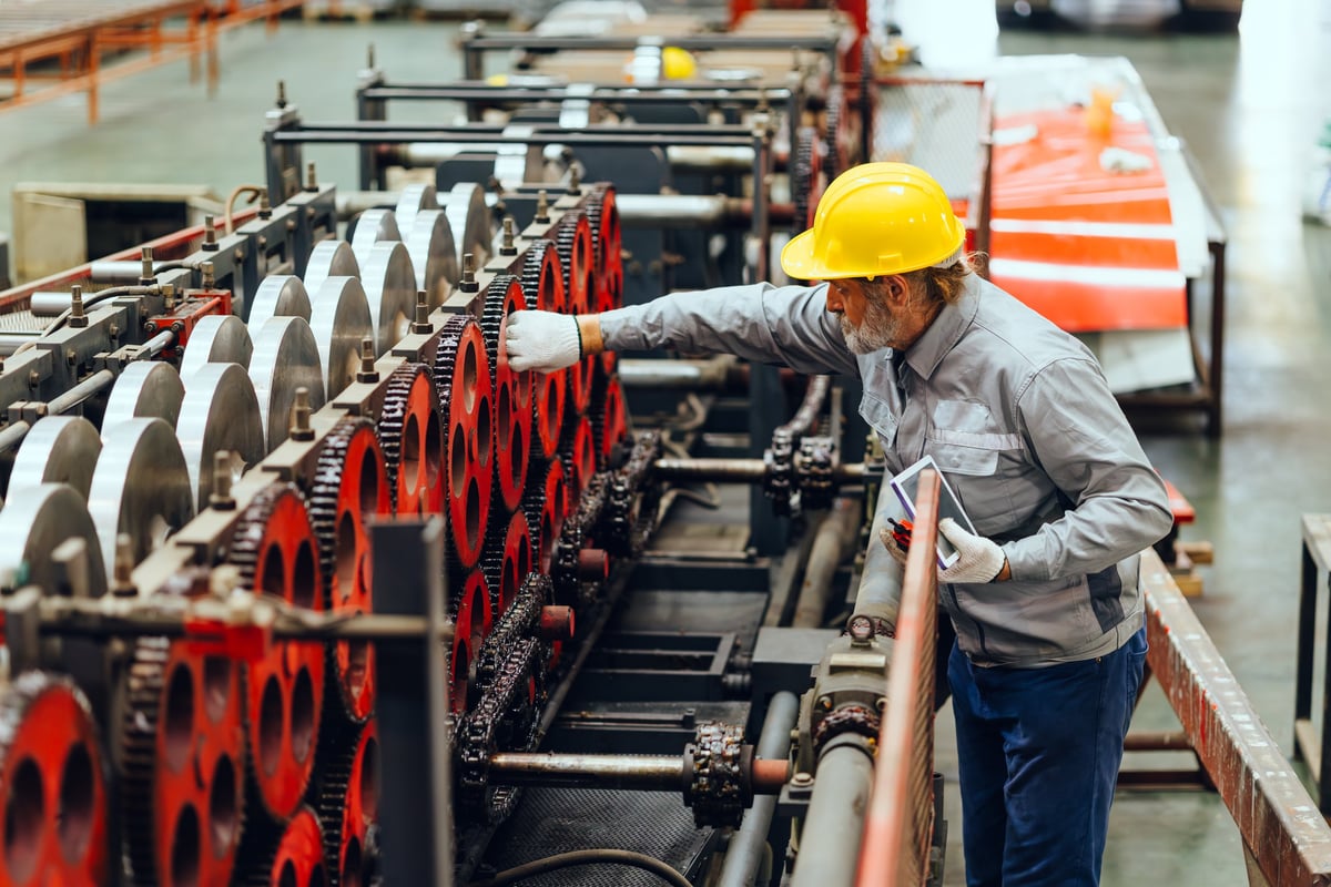 Senior engineer reviewing operations in manufacturing facility