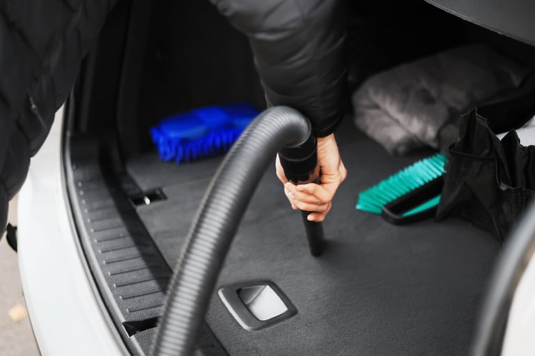 Vacuuming car interior at detail shop