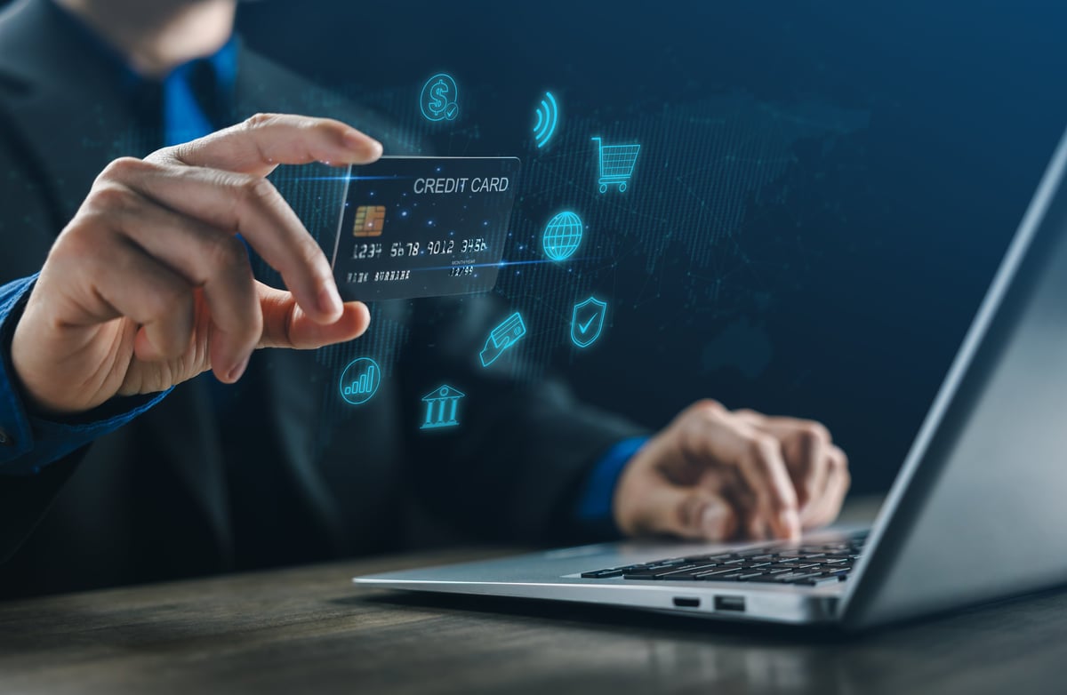 A businessman using a credit card for online payment on a laptop, symbolizing digital banking, fintech innovation, secure transaction, and modern e-commerce.