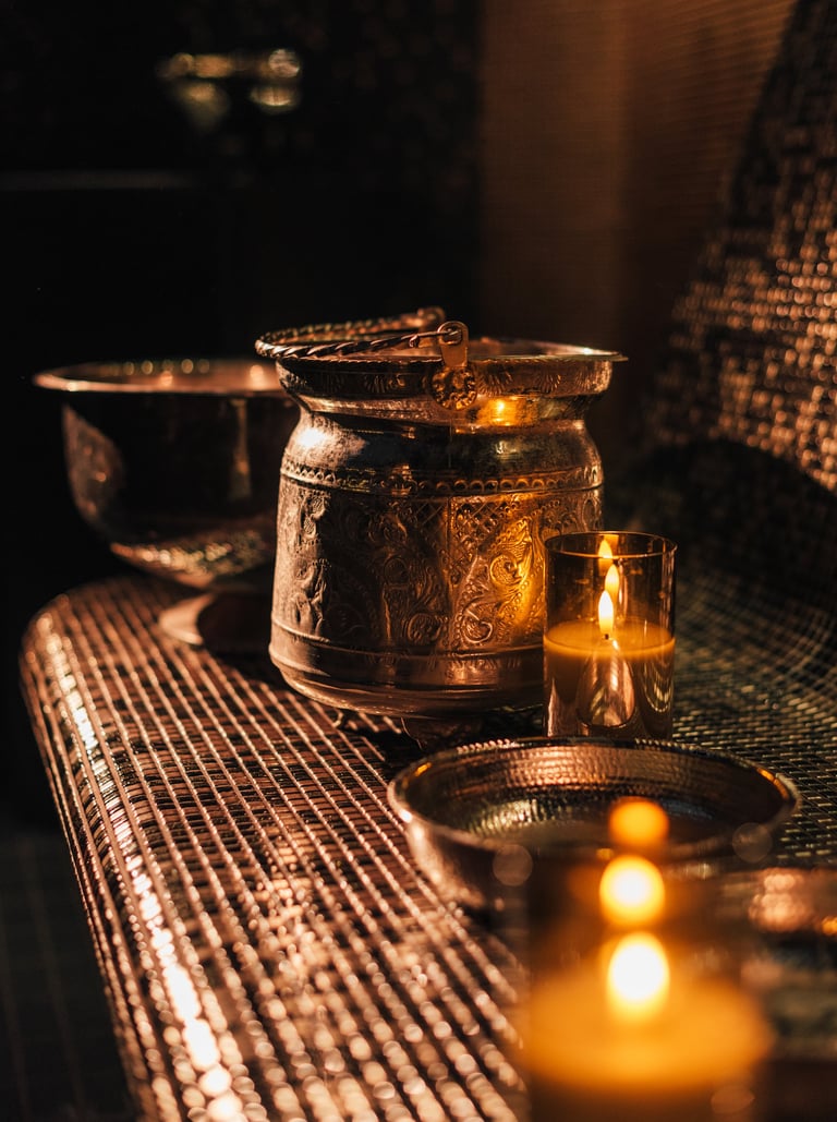 Hammam and sauna accessories with copper bucket, washing bowl, and candles — warm spa atmosphere for the steam ritual