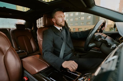Professional businessman driving a luxury car in formal suit