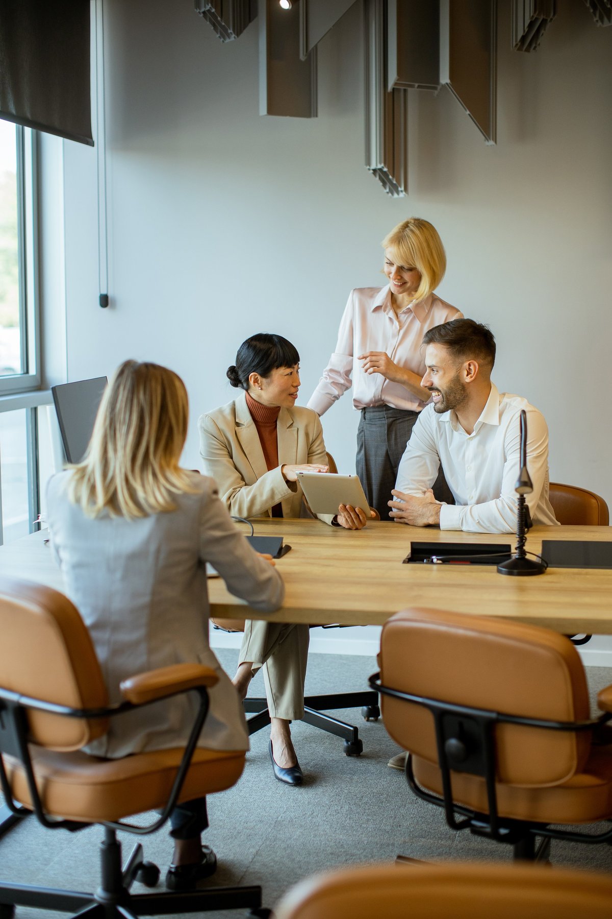 A group of four professionals engage in a meeting inside a contemporary office.
