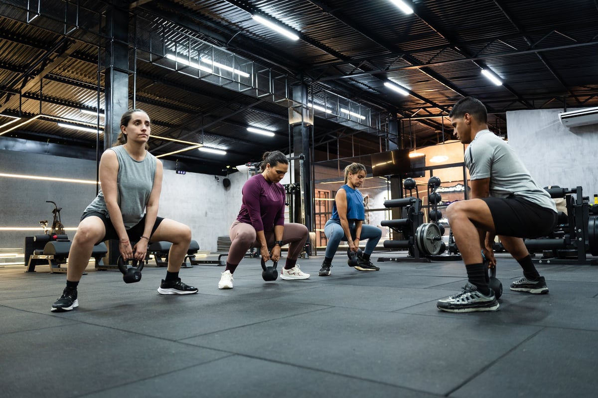Group fitness class performing exercises together in a modern studio