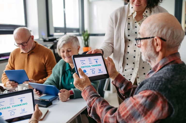 Volunteer teaching seniors digital literacy on a tablet
