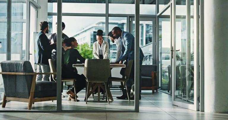Senior executives in a boardroom reviewing financial documents and strategic dashboards