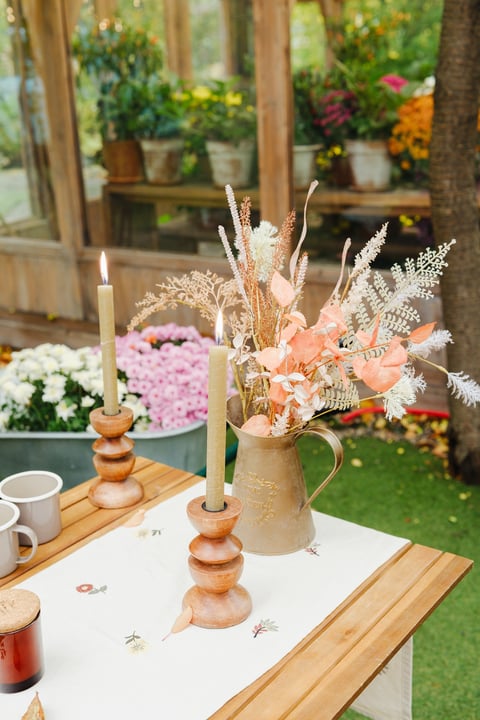 Candles in wooden holders with dried florals — soft romantic picnic detail