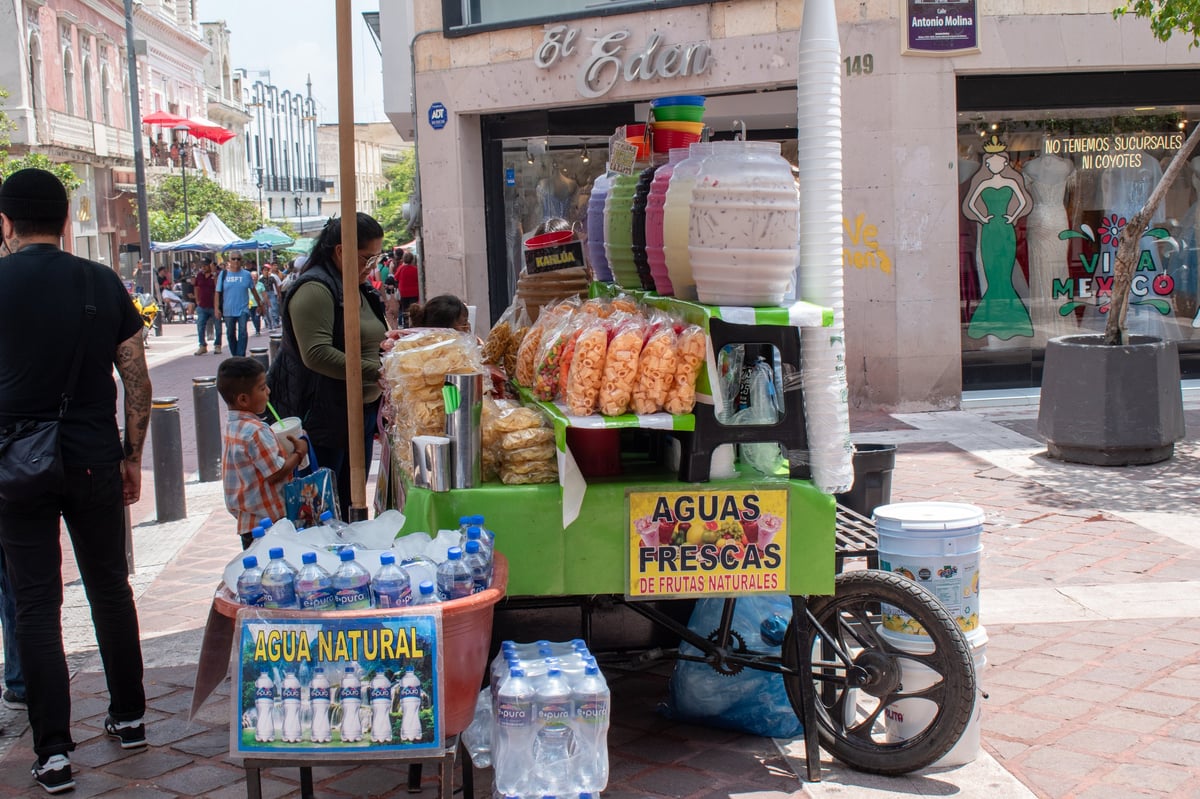 Vibrant street vendor stall selling refreshing aguas frescas and popular fried snacks