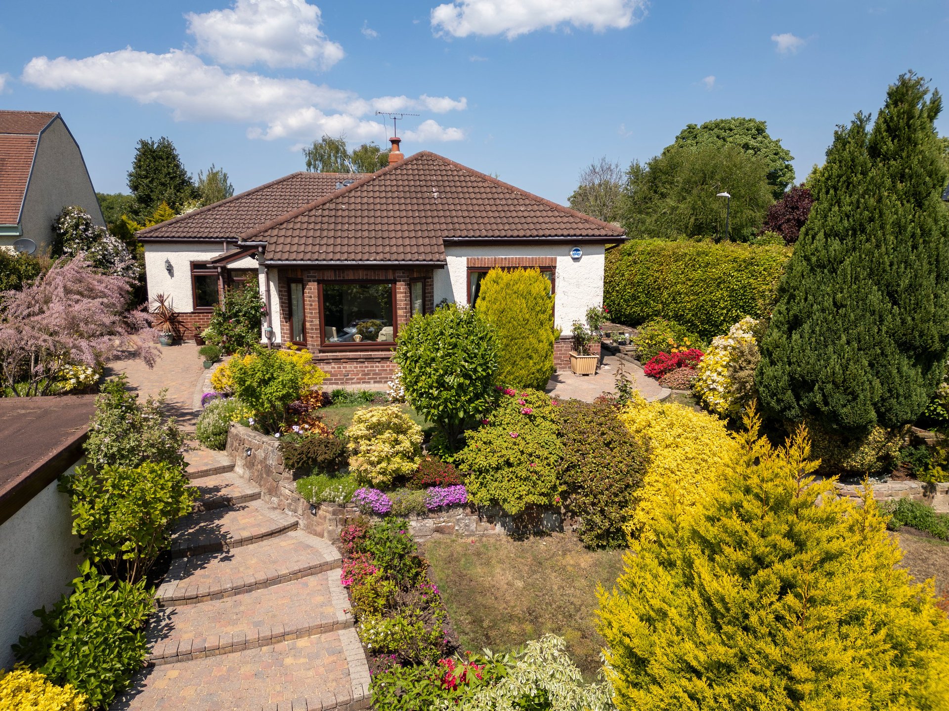 Front garden and pathway steps of a suburban bungalow in springtime