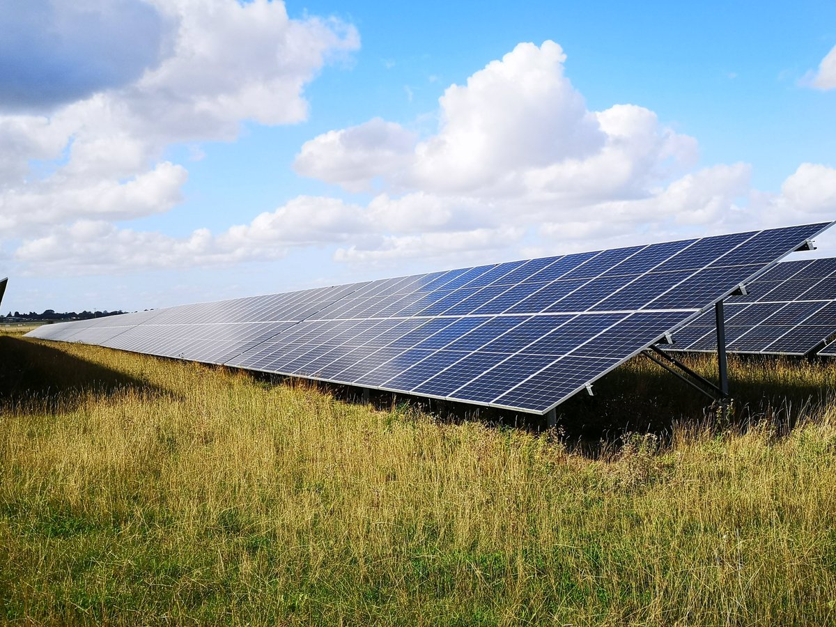 Solar panels in open countryside under a blue sky