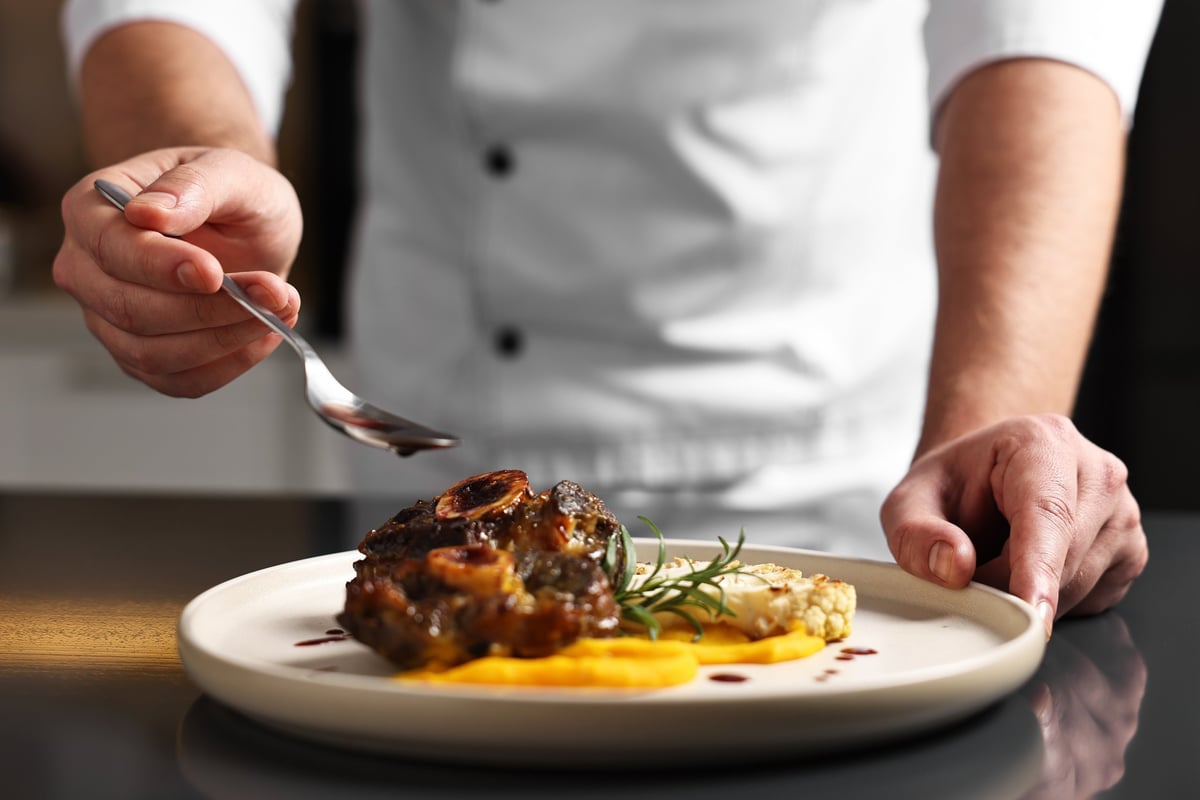 Professional chef adding sauce to a dish