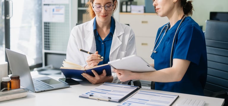 Médicos y especialistas colaborando en entorno clínico moderno con revisión de caso
