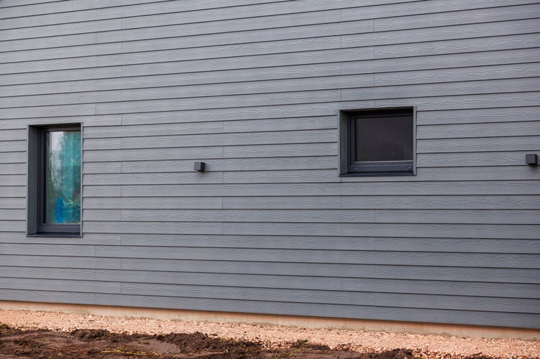 Grey horizontal lap siding with subtle woodgrain and dark framed windows