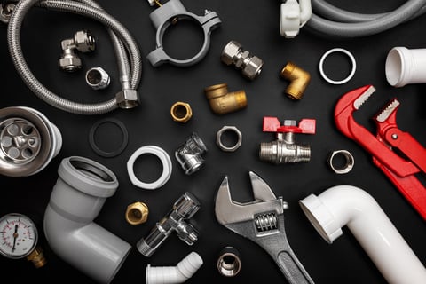 Plumbing tools and fittings on black background