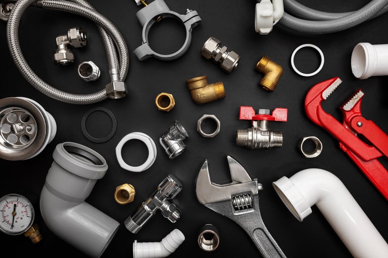 Plumbing and heating tools on black background