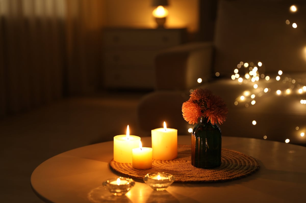 Burning candles and fresh flowers arranged in warm light
