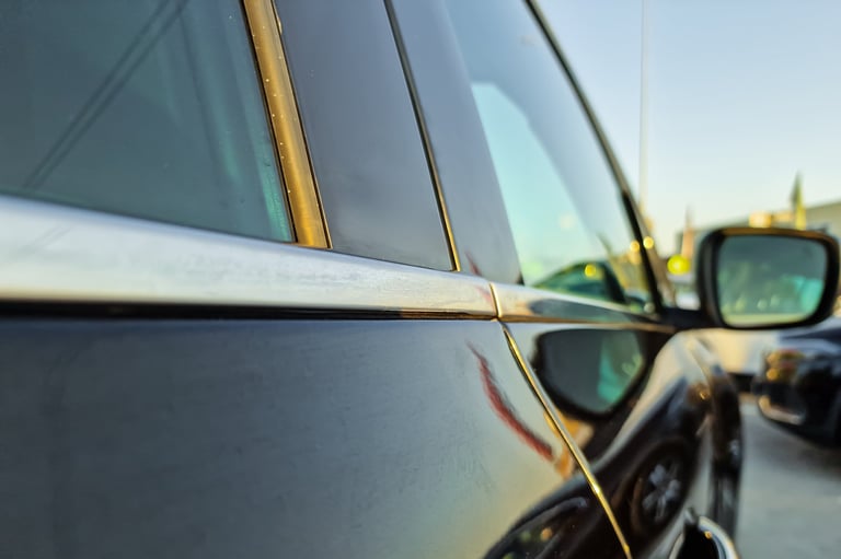 Shiny black car with golden sunset light highlighting contours