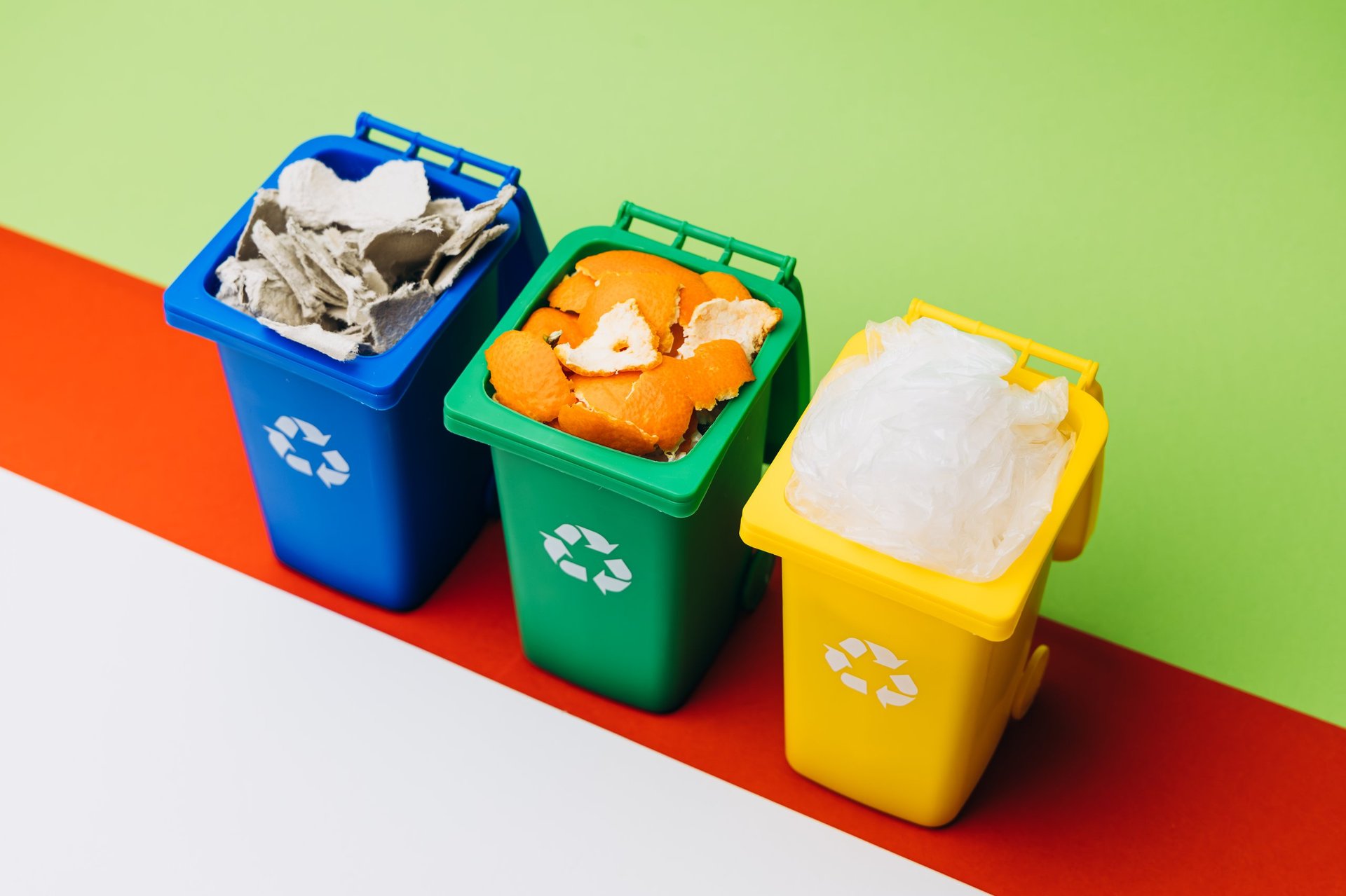 Colorful recycling bins with various sorted waste materials