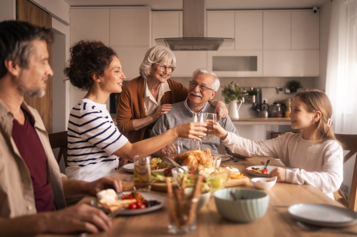 Multi-generational family enjoying a meal together in a modern kitchen, sharing happiness and connection