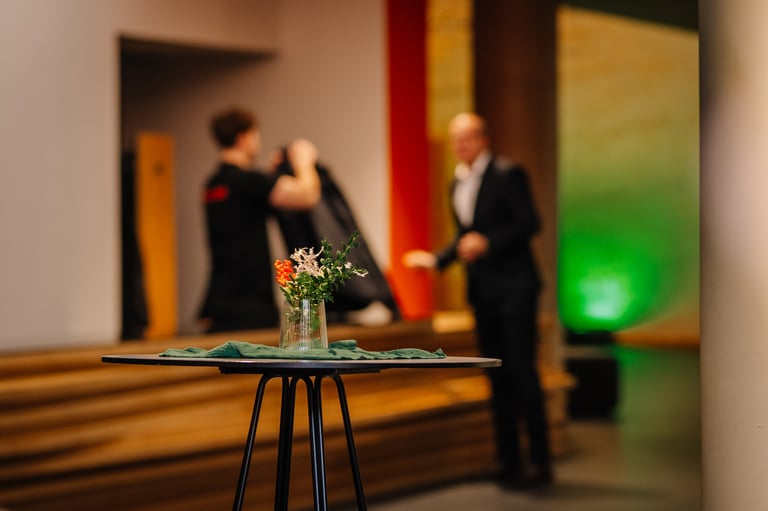 Stilvoll gedeckter Tisch mit Blumendekoration in modernem Event-Ambiente
