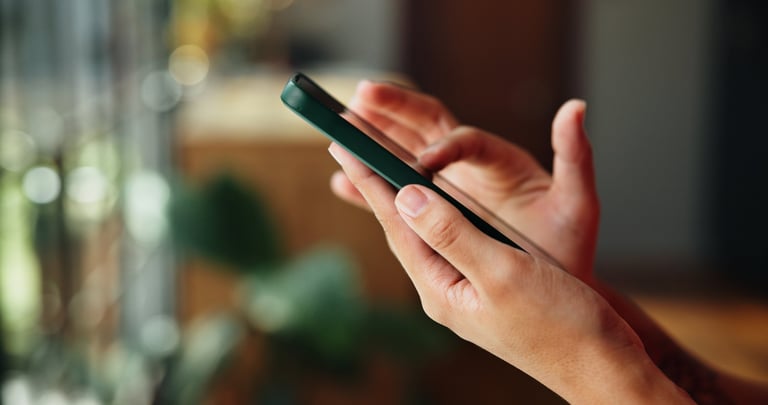 Person checking their phone while monitoring a site