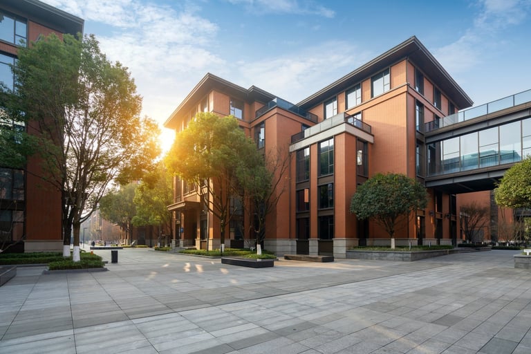 Red brick office building set in a green park setting, representing commercial properties served by Comfort Pest Control