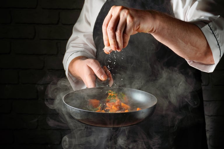 Chef preparing a dish in a busy restaurant kitchen