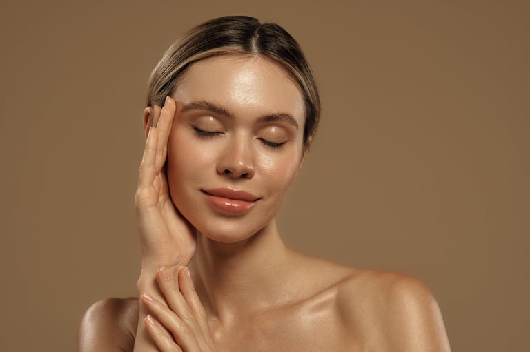 Close-up portrait of a young woman touching her face with glowing skin