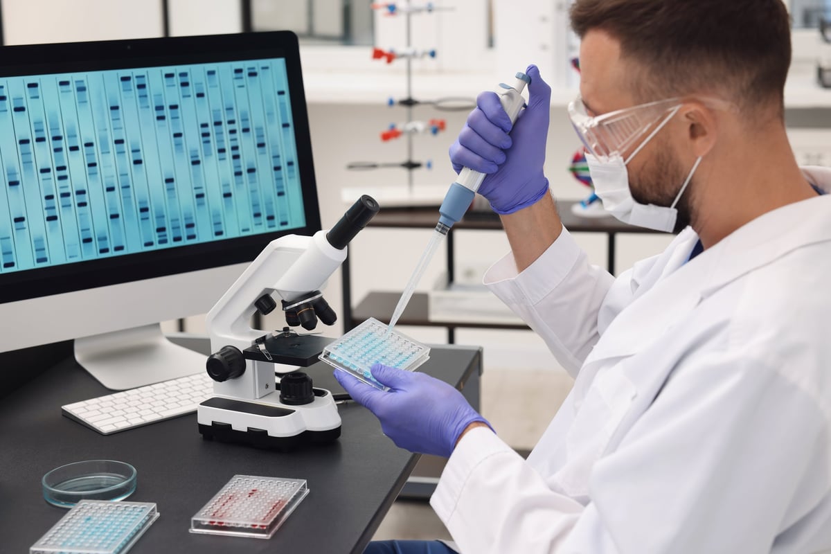 Scientist performing genetic analysis with micropipette in laboratory